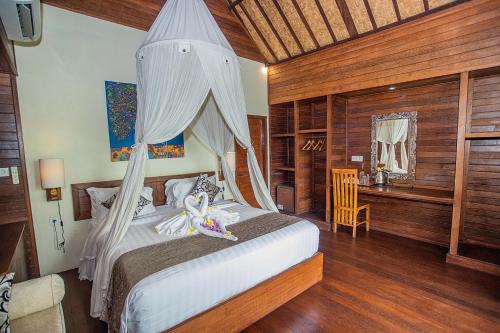 蓝梦岛D'Muncuk Huts Lembongan的一间卧室配有一张带蚊帐的床