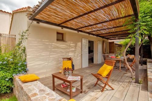 卡尔维Very warm villa "Acacia" with beautiful garden - 4 6 people的一个带凉棚和桌椅的庭院