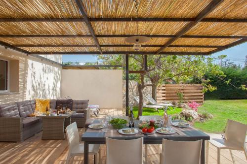 卡尔维Villa Albizzia with terrace and garden 6 8 people的凉亭下带桌椅的天井