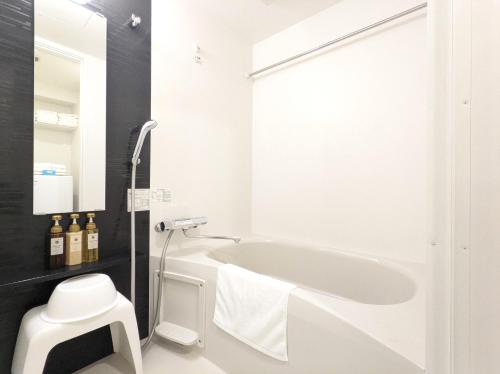 大阪ESLEAD HOTEL Osaka Ebisu的白色的浴室设有浴缸和水槽。