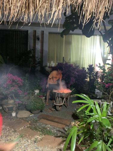 邦美蜀Chà Là retreat BMT的坐在花园壁炉前的人
