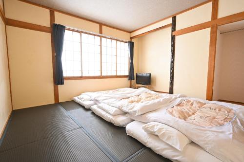 茅野Hütte Jil Shirakabako的窗户客房内的一张大床