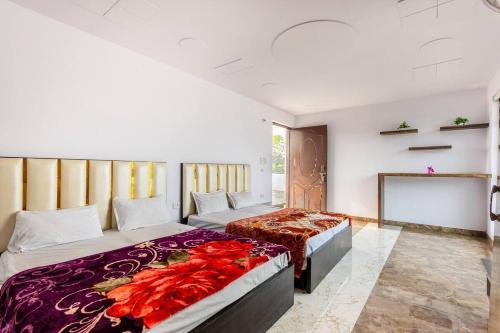 古尔冈Aravali hills resort的一间带两张床和电视的卧室