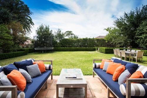 悉尼Victorian Masterpiece的庭院里配有带橙色枕头的蓝色沙发