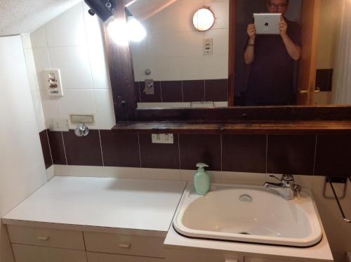 拉特乌伊莱Condominio Colmet的一位妇女拍着浴室水槽的照片