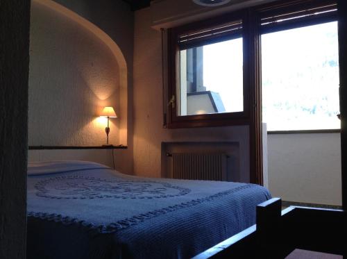 拉特乌伊莱Condominio Colmet的一间卧室设有一张床和一个窗口