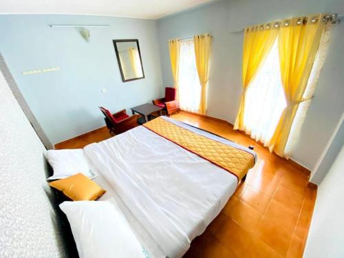 乌提BOB Leisure的卧室配有一张白色大床和黄色窗帘