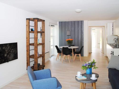 阿灵厄4 person holiday home in Allinge的客厅配有蓝色的沙发和桌子