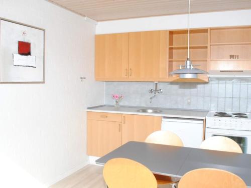 阿灵厄4 person holiday home in Allinge的厨房配有木制橱柜和桌椅
