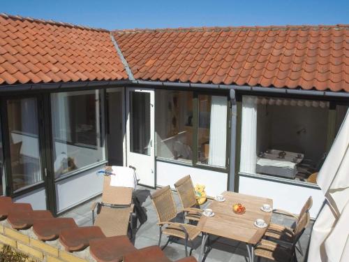 阿灵厄4 person holiday home in Allinge的一个带桌椅的庭院和一个屋顶