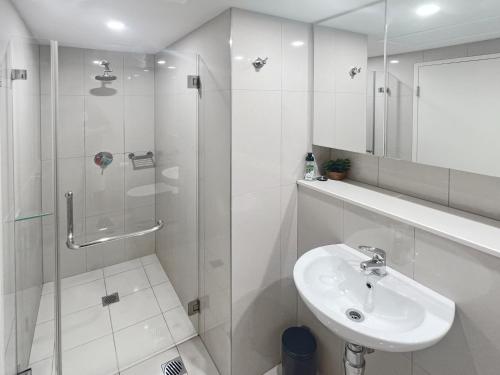 达尔文Welcome Homestay Cityscape的白色的浴室设有水槽和淋浴。