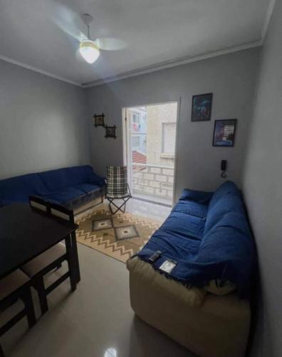 蒙加瓜Apartamento Praia de Mongaguá的一间卧室配有一张床、一张桌子和一个窗户。