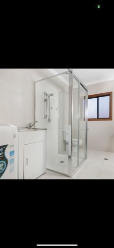 悉尼68 Frederick的带淋浴和盥洗盆的白色浴室
