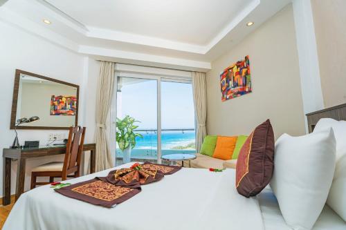 Cam LâmOcean Waves Resort Cam Ranh的一间卧室设有一张床,享有海景