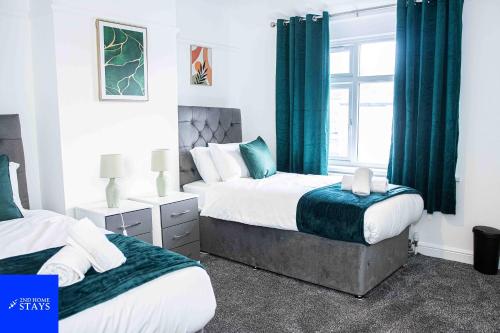 特伦特河畔斯托克2ndHomeStays-3 Bedroom House - Sleeps 6 - City Centre -Stoke-on-Trent的一间卧室设有两张床和窗户。