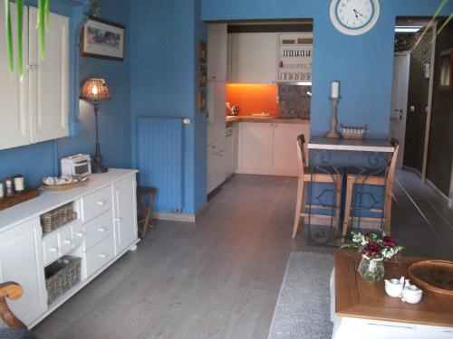哈瑟尔特海特德麦斯杰公寓的一间厨房,拥有蓝色的墙壁,配有桌子和柜台