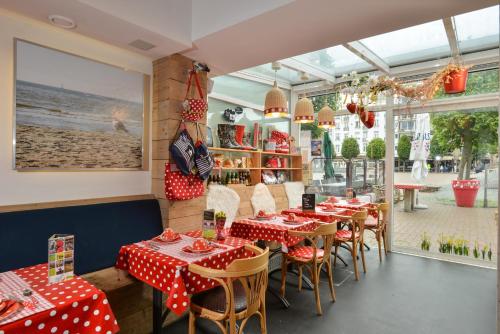 德帕内安扎酒店的餐厅设有红色和白色的波尔卡圆顶桌椅