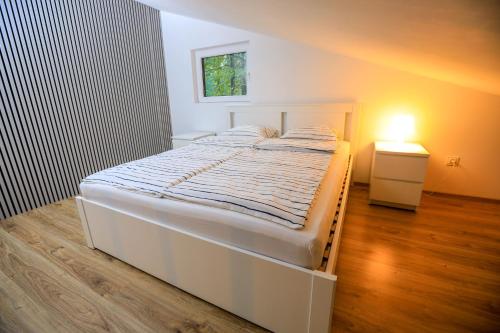 Zalesie GórneBizon Village的卧室配有白色的床和床头柜