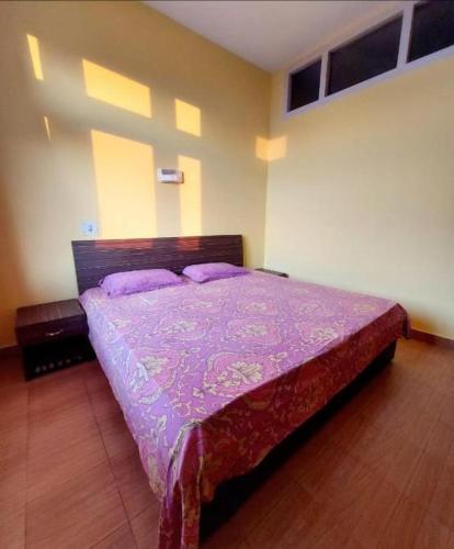 乌提Hotel Hill Valley, Ooty的一间卧室配有一张带紫色棉被的床
