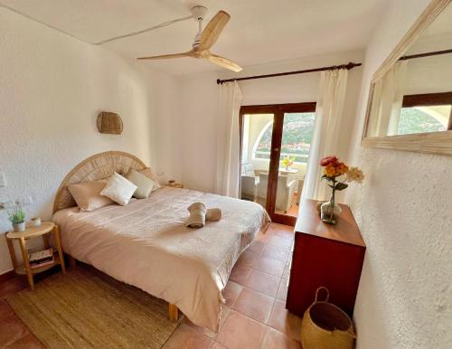 卡拉莫若尔Beachfront Apartment in Cala Morell的一间卧室配有一张带风扇和窗户的床。