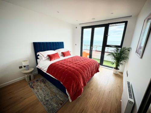 拉姆斯盖特Stunning Beach Front Apartment with Sea views, FREE Parking & Balcony的一间卧室配有一张带红色毯子的床