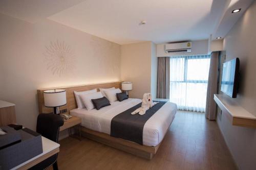 曼谷Iconic Hotel的酒店客房设有一张大床和一台电视。