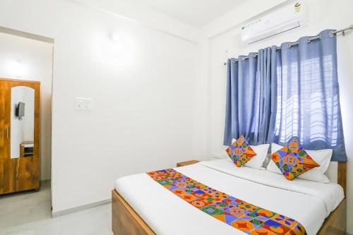 纳西克FabHotel Blue Ocean MNJ Resort的一间卧室配有一张蓝色窗帘的床