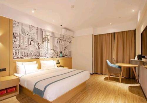 海口City Comfort Inn Haikou Zhongjie Road Walking Street的酒店客房设有一张大床和一张书桌。