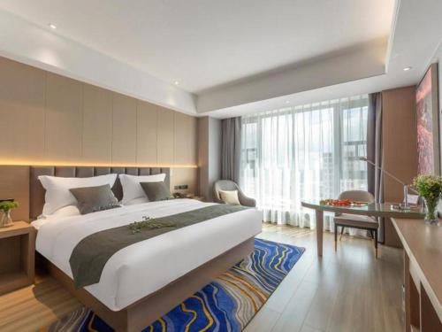 昆明Gya Hotel Kunming Zijin Center Xiaodongcun Metro Station的酒店客房设有一张大床和一张书桌。