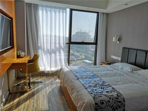 ZhuanwachangSuper 8 Hotel Changchun Jingyue Xincheng Street Bashu Yingxiang的一间卧室配有一张床、一张书桌和一个窗户。