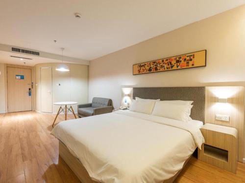 济南Hanting Hotel Jinan Guo Branch的酒店客房带一张大床和一把椅子