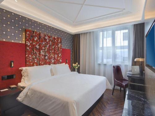 QingxiuHanting Hotel Nanjing Jiangning Binjiang Development Zone Park的卧室配有一张白色大床和一张书桌