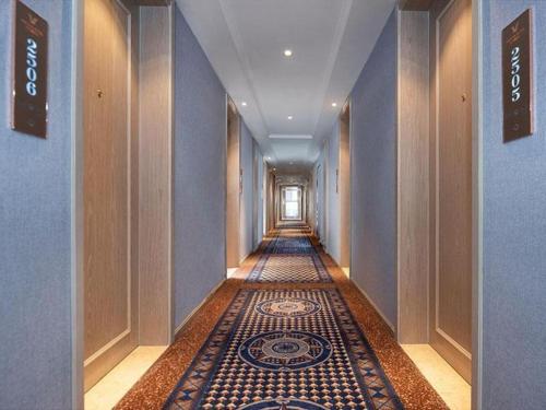 昆明Vienna Hotel Kunming Dashanghui的大楼内铺着瓷砖地板的走廊