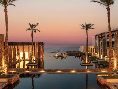古瓦伊Amirandes Grecotel Boutique Resort的 ⁇ 染酒店,拥有游泳池和棕榈树