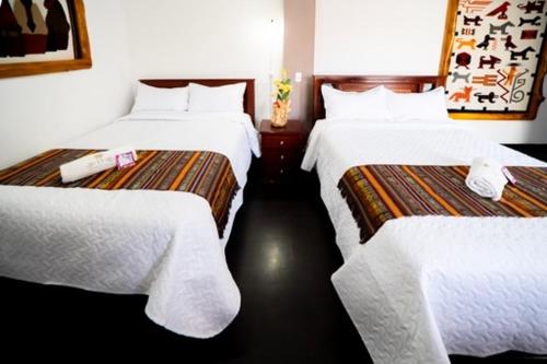 奥塔瓦洛Tourist house 1的酒店客房,配有两张带白色床单的床