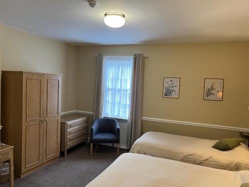 加斯唐Royal Oak Hotel, Garstang的一间卧室设有两张床、一个窗口和椅子