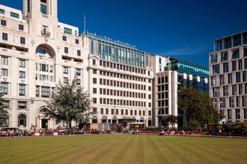 伦敦Montcalm Royal London House, London City的前面有草地的大建筑