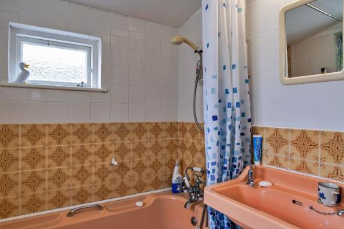 森嫩Finest Retreats - Lewcott的浴室配有橙色浴缸和水槽