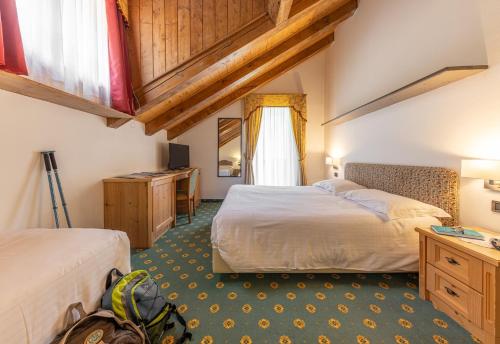 圣马蒂诺-迪卡斯特罗扎Hotel Plank的酒店客房配有两张床和一张书桌