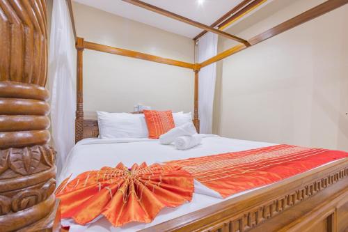 迪亚尼海滩Waiti homes的一间卧室,床上有橙色的连衣裙