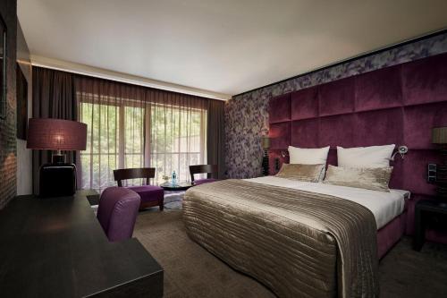 格拉德贝克格拉德贝克凡德瓦克酒店的一间卧室设有一张大床和紫色的墙壁