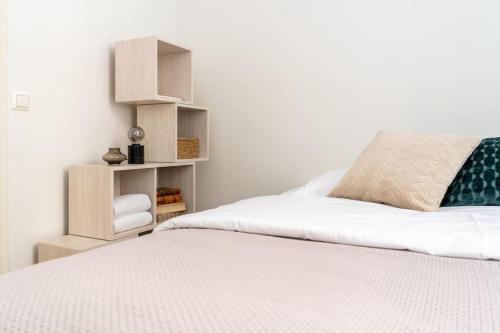 赫尔辛基Cozy Studio with private Sauna的一间卧室配有一张白色大床和书架