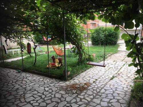 斯特鲁加Rooms Struga的花园里有狗坐在秋千里