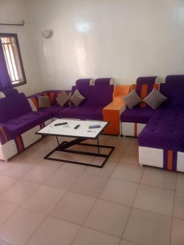 博博迪乌拉Résidence privée的客厅配有紫色沙发和茶几