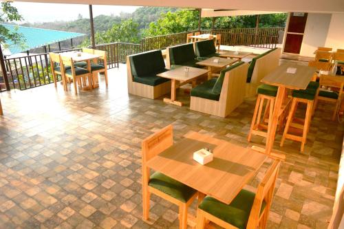 阿姆波尔Cashew leaf resort的一间带桌椅的餐厅以及一个阳台