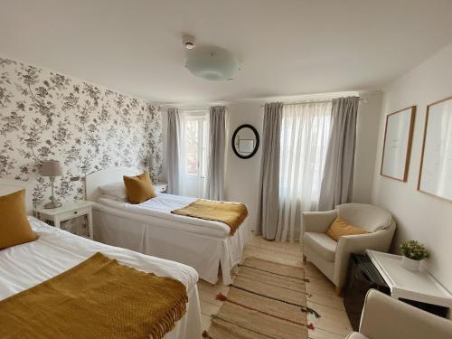 格兰纳Smålandsgården的一间小卧室,配有两张床和椅子