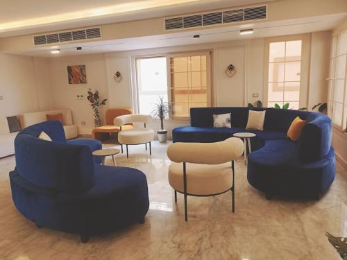 Sheikh ZayedRoyal Elegance Room的大型客厅配有蓝色的沙发和椅子