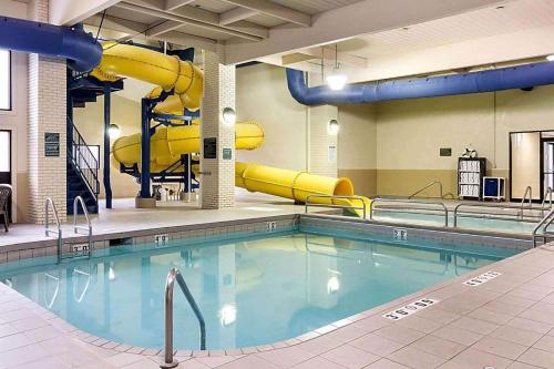 詹姆斯镇Baymont by Wyndham Jamestown Conference Center & Water Park的大楼内一个带滑梯的游泳池