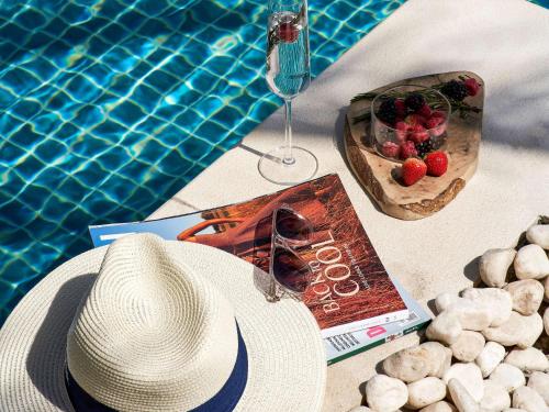 迪拜迪拜市区索菲特酒店的游泳池畔的帽子和书
