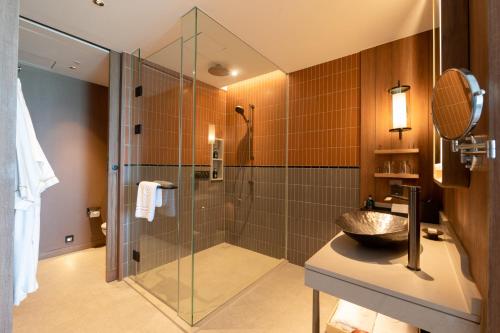 北芭堤雅Centara Grand Mirage Beach Resort Pattaya的带淋浴和盥洗盆的浴室